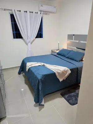 a bedroom with a blue bed and a window at Luxury Apartment in Boca Chica in La Julia