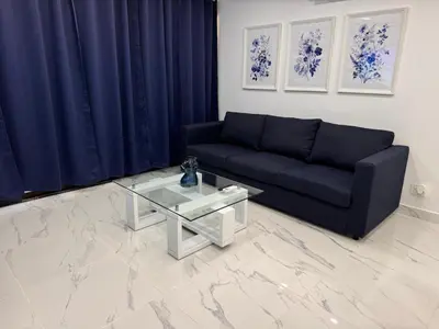 a living room with a black couch and a glass table at Blue Oasis Luxury in Sosúa