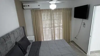 a bedroom with a bed and a flat screen tv at New and Comfortable Apartment in Ciudad Juan Bosch in San Isidro
