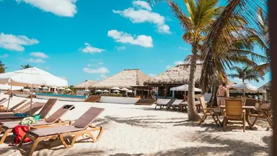 a beach with a bunch of chairs and umbrellas at New Jacuzzi Beach Fun 2 bedroom at Cana Rock Star in Punta Cana