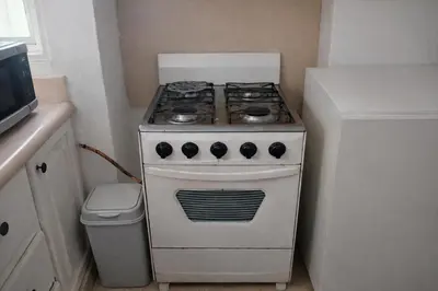 a white stove in a kitchen with a trash can at Villa La Olita in La Puntica de Juan Dolio
