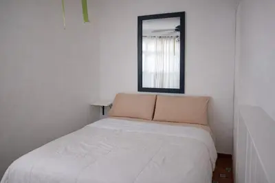 a white bed in a room with a mirror at Villa La Olita in La Puntica de Juan Dolio