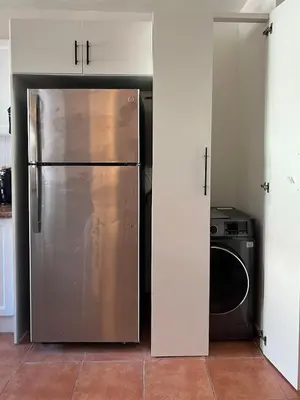 a kitchen with a stainless steel refrigerator and a microwave at Cozy 3 Bedroom Apartment with Pool & Private Beach in Bávaro Punta Cana in Punta Cana
