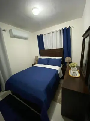 a bedroom with a blue bed and a table at Isidro 102 Comfrot Stay in San Isidro