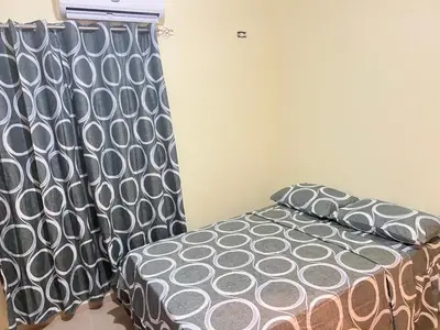 a bedroom with a bed with a black and white comforter at Casa vacanza, Mendosa in Bayaguana