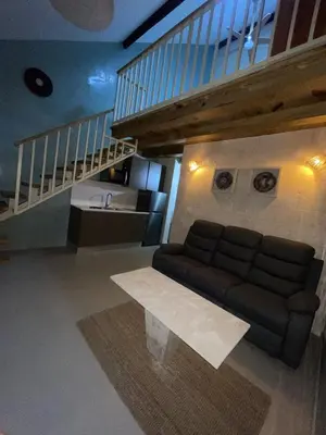 a living room with a couch and a staircase at Mila Apartment in Bayahibe