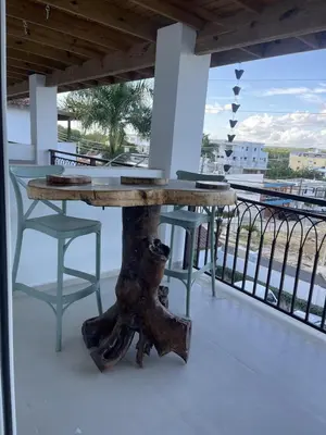 a table on a balcony with a view of the ocean at Mila Apartment in Bayahibe