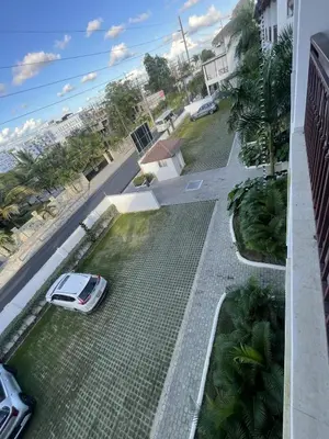 a white car parked on a street next to the ocean at Mila Apartment in Bayahibe