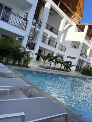 a hotel with a swimming pool in front of a building at Mila Apartment in Bayahibe