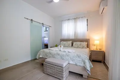 a bedroom with a large bed and a night stand at Pro Cab Apartment - Washer - BBQ in Cabarete