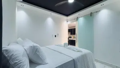 a white room with a bed with white sheets and pillows at One Bedroom Apartment - Wi-Fi - BBQ in Sosúa