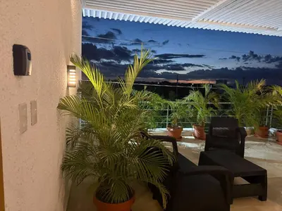 a living room with a couch and potted plants at Luxurious 3-Bedroom Apartment in Juan Dolio with Pool Access in Juan Dolio