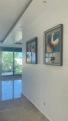 two framed pictures on a wall in a room at Luxurious 3-Bedroom Apartment in Juan Dolio with Pool Access in Juan Dolio
