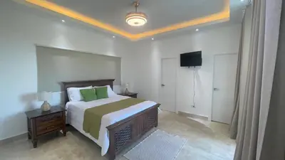 a bedroom with a bed and a television in it at Spacious 3-Bedroom Apartment with Pool Access in Juan Dolio in Juan Dolio
