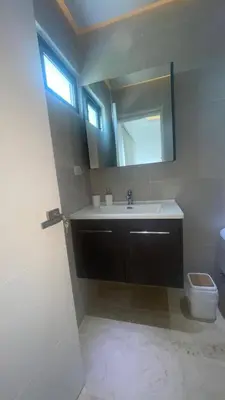 a bathroom with a sink and a mirror and a toilet at Spacious 3-Bedroom Apartment with Pool Access in Juan Dolio in Juan Dolio
