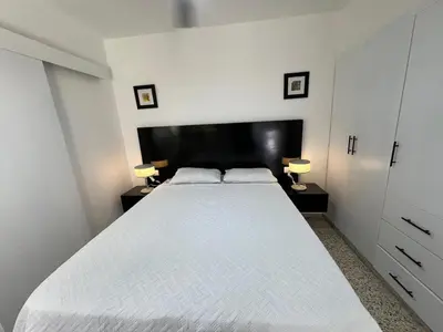 a bedroom with a large white bed with two lamps at Bijoc 01 Apartment in San Felipe de Puerto Plata