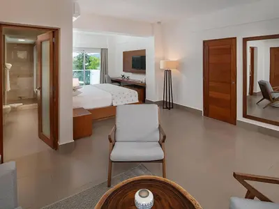 a bedroom with a bed and a desk and a chair at Presidential Suites 1 bedroom with kitchen in Cabarete
