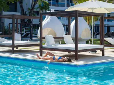 a woman laying in the water in a swimming pool at Presidential Suites 1 bedroom with kitchen in Cabarete