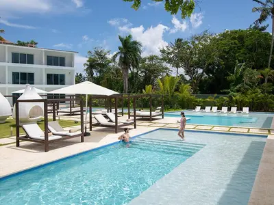 two people in a swimming pool at a resort at Presidential Suites 1 bedroom with kitchen in Cabarete