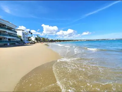 a beach with the ocean and buildings on it at Presidential Suites 1 bedroom with kitchen in Cabarete