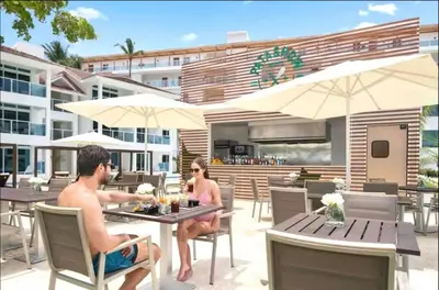 two men sitting at a table on a patio at Presidential Suites 1 bedroom with kitchen in Cabarete