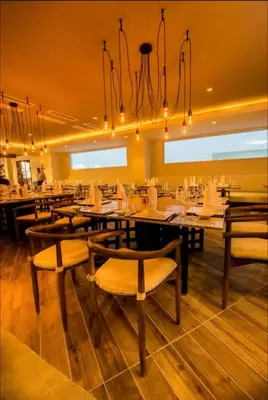 a restaurant with tables and chairs and a chandelier at Presidential Suites 1 bedroom with kitchen in Cabarete