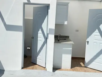 a bathroom with a door leading to a sink at Beach front apartment in Puerto Plata