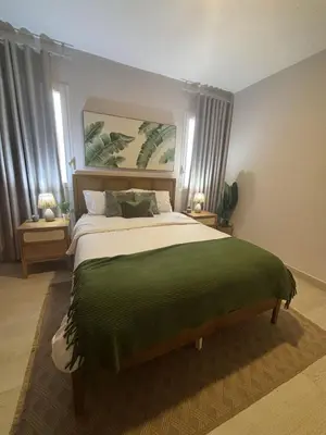 a bedroom with a large bed with a green blanket at Garden Breeze Pool & Beach Escape l Bali 102 in La Laguna