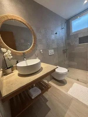 a bathroom with a sink and a toilet and a mirror at Garden Breeze Pool & Beach Escape l Bali 102 in La Laguna