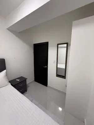 a bedroom with a bed and a black door at Moon Apartamentos C4 in San Cristóbal