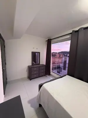 a bedroom with a bed and a tv and a window at Moon Apartamentos C1 in San Cristóbal