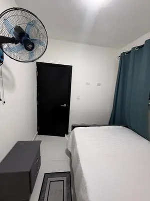 a small bedroom with a bed and a fan at Moon Apartamentos C1 in San Cristóbal