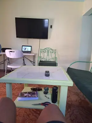 a living room with a table and a tv at Fresh