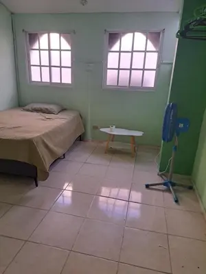 a room with a bed and a table and two windows at Fresh