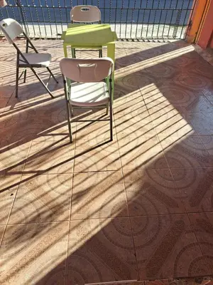a green table and two chairs on a floor at Fresh
