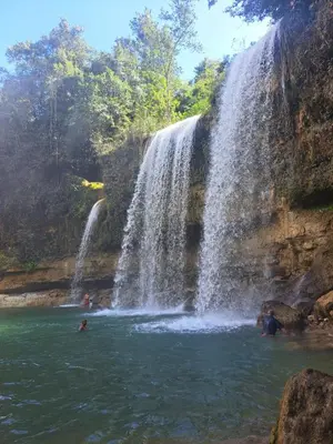 a group of people swimming in a waterfall at Fresh