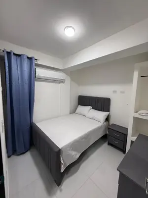 a bedroom with a bed with a blue curtain at Moon Apartamento C2 in San Cristóbal