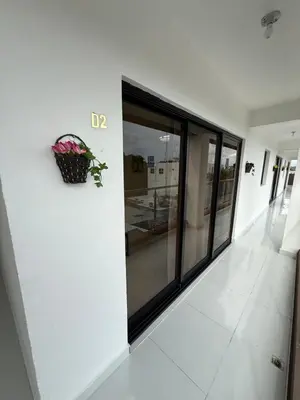 a white hallway with a potted plant on a wall at Moon Apartamentos D2 in San Cristóbal