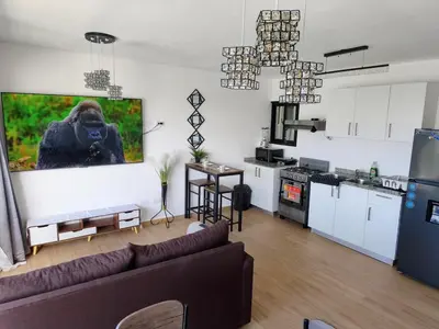 a living room with a couch and a kitchen at Brisa del Mar Punta Cana Apartment in Punta Cana