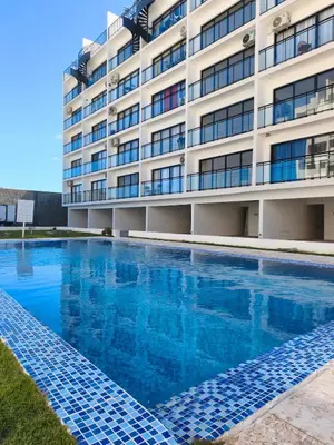 a swimming pool in front of a building at Brisa del Mar Punta Cana Apartment in Punta Cana