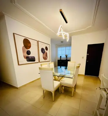 a dining room with a glass table and white chairs at Residencial ambar lll in Santiago de los Caballeros