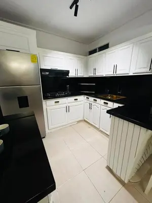 a kitchen with white cabinets and black counter tops at Residencial ambar lll in Santiago de los Caballeros