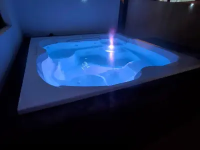 a blue bath tub with a light in a room at Pure relax in Bavaro La Casita de Giò in Punta Cana