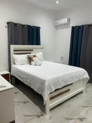 a bedroom with a large bed with blue curtains at Tropical oasis rentas in Las Terrenas