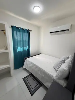 a bedroom with a bed with a blue shower curtain at Moon Apartamentos D3 in San Cristóbal