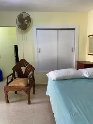 a bedroom with a bed and a chair and a fan at Nido del patio, 40 min to Bocachica beach 5 center in La Piedra