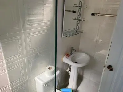 a white bathroom with a sink and a toilet at Nido del patio, 40 min to Bocachica beach 5 center in La Piedra