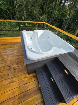 a white bath tub sitting on a deck at Cabaña Silencio Verde in Jarabacoa