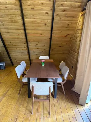 a table and chairs in a room with wooden walls at Cabaña Silencio Verde in Jarabacoa