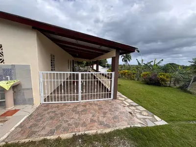 a house with a white gate in a yard at Casa de campo El Bonao in Higuey